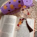 lila színű pohár szívószállal, üvegpohárral és könyvjelzővel tök és levél mintával