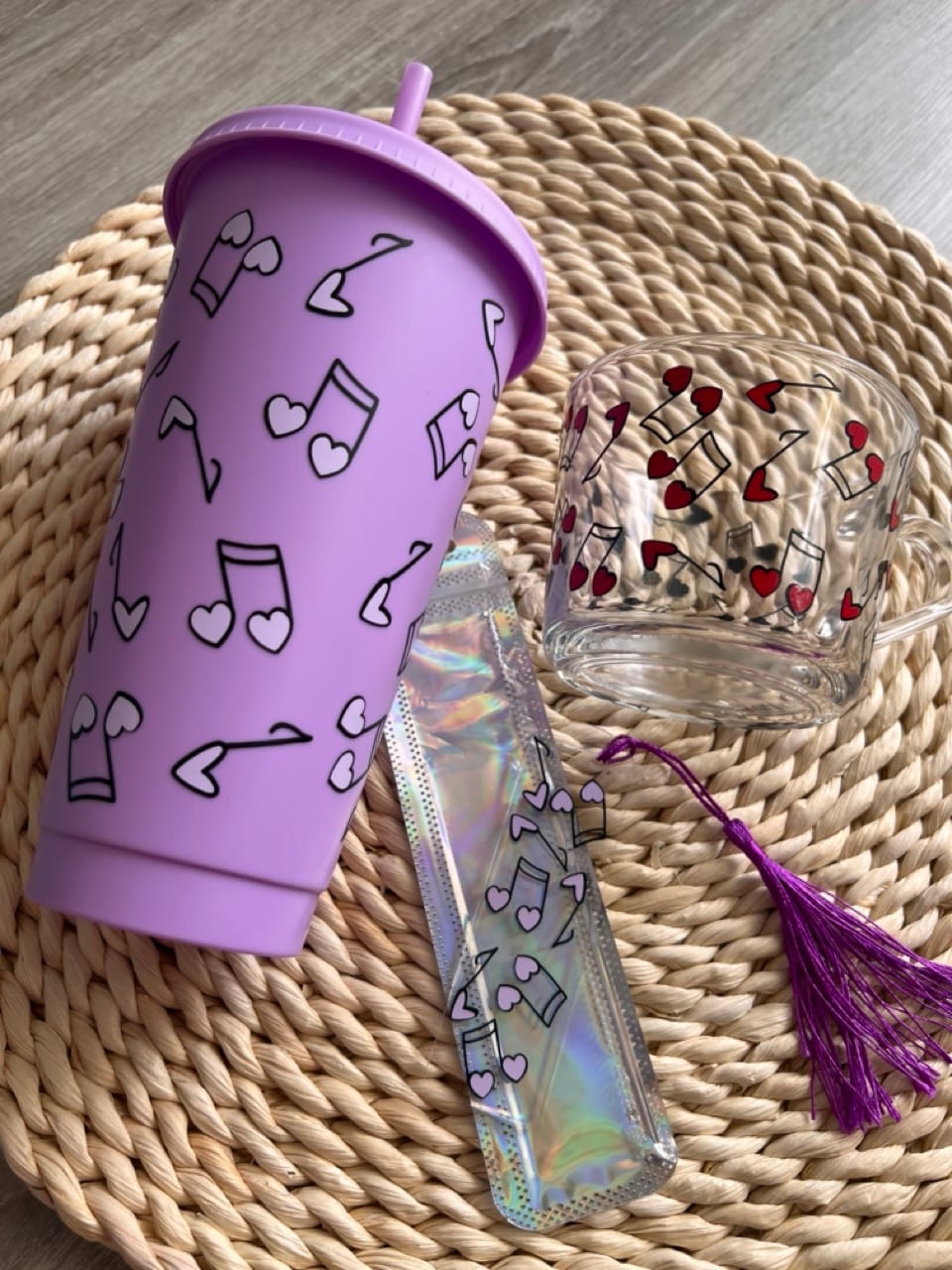 lila színű pohár szívószállal, üvegpohárral és könyvjelzővel hangjegy mintával