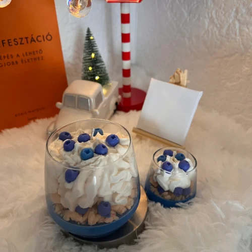 blueberry-parfait-frozen-spruce-illatu-desszert-gyertya kék alapon keksz morzsa tetején habbal és áfonyaszemekkel