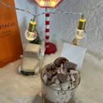 chocolate-cookies-rich-chocolate-illatu-desszert-gyertya barna csokis alapon fehér hab rajta cskidarabok