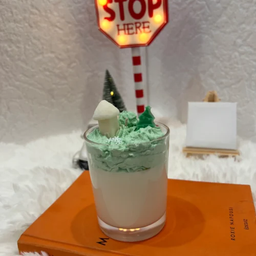 home-sicilian-lemon desszert gyertya fehér alapon zöld habbal és egy fehéz házikóval és fenyőfával