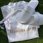 Elegáns menyasszonyi box fehér szatén köntössel, papuccsal, egyedi vállfával és pezsgőspohárral